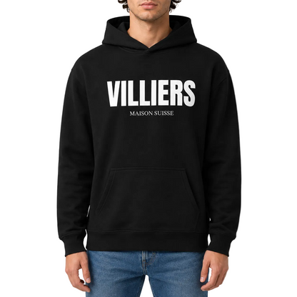 Herren Oversize Hoodie von VILLIERS MAISON SUISSE in Schwarz mit weißem Logo auf der Brust, getragen von einem Model in der Frontansicht.