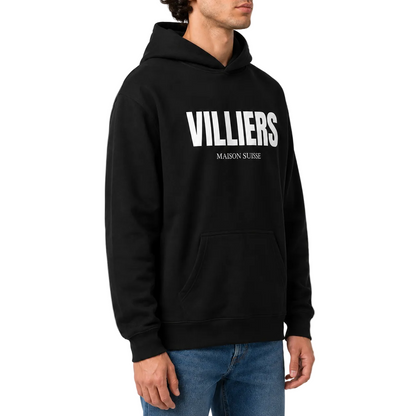 Herren Oversize Hoodie von VILLIERS MAISON SUISSE in Schwarz mit weißem Logo auf der Brust, getragen von einem Model in der Seitenansicht